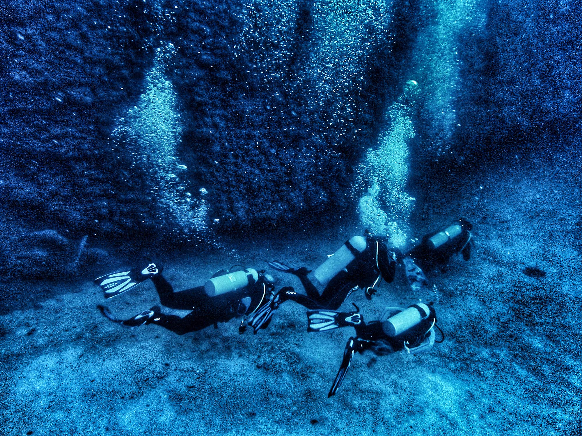 Mehrere Taucher Steilwand