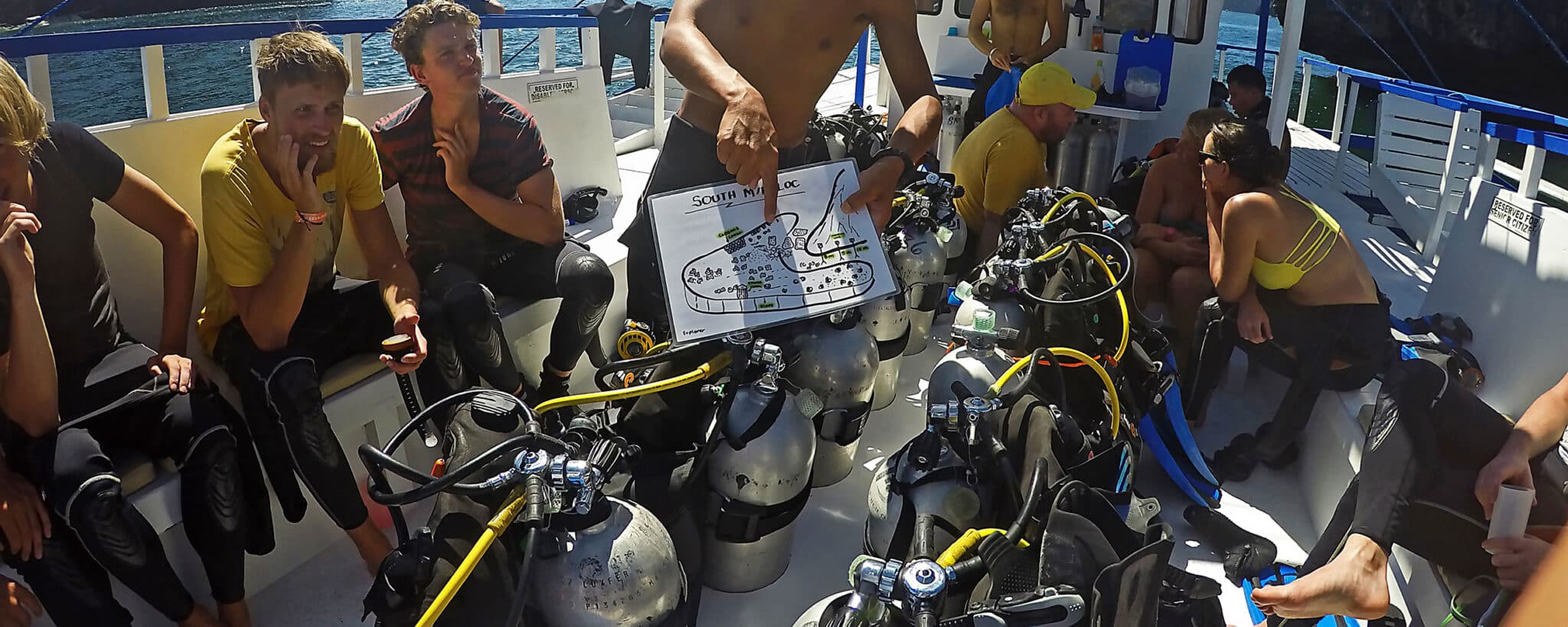 Taucher am Boot mit Tauchplatz Erklärung Briefing